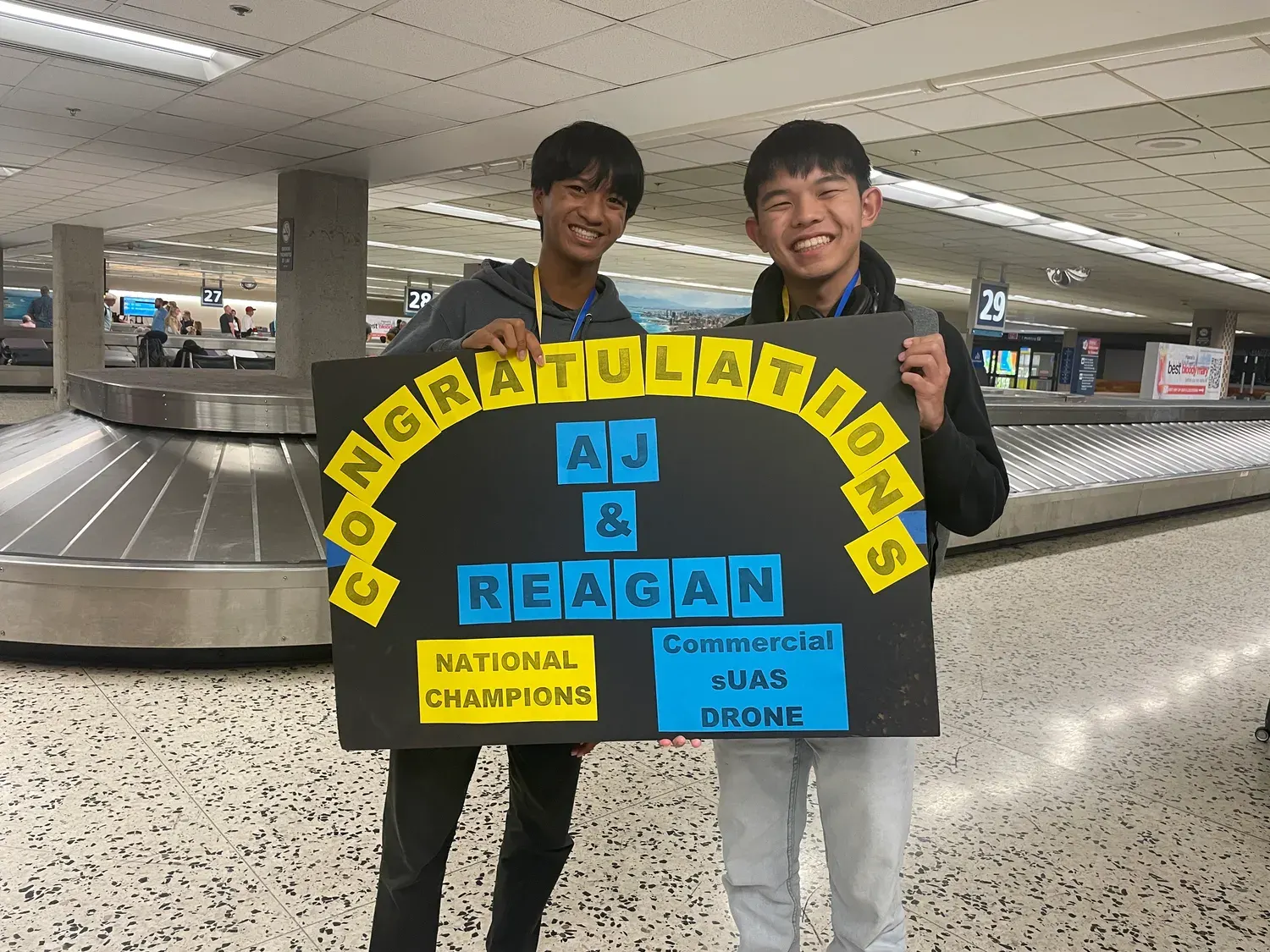 AJ and teammate Reagan Chinen with a national-champions banner
