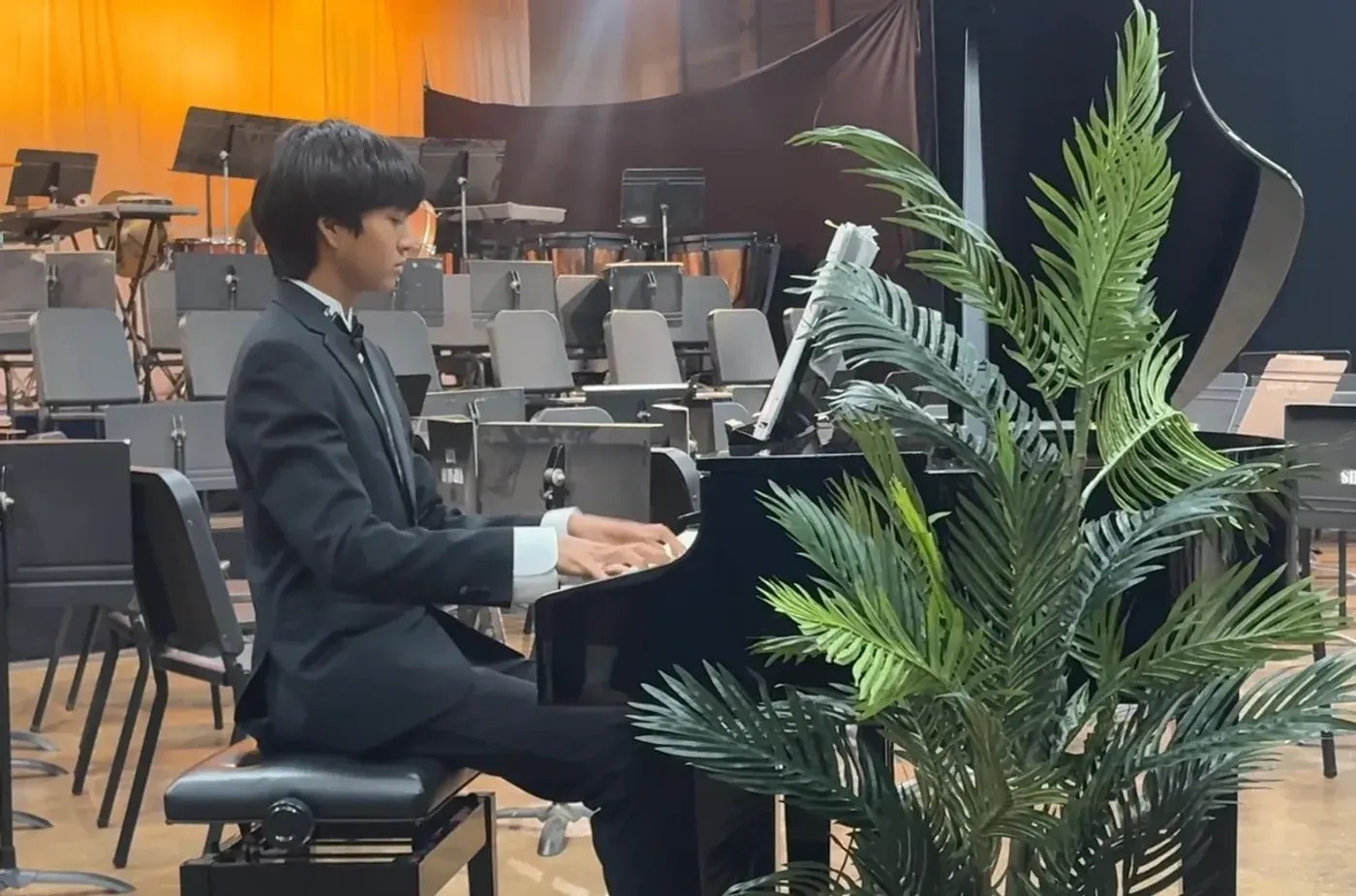 AJ playing a grand piano in concert