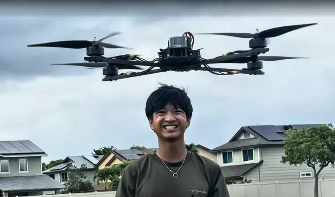 AJ standing under an early test drone in flight