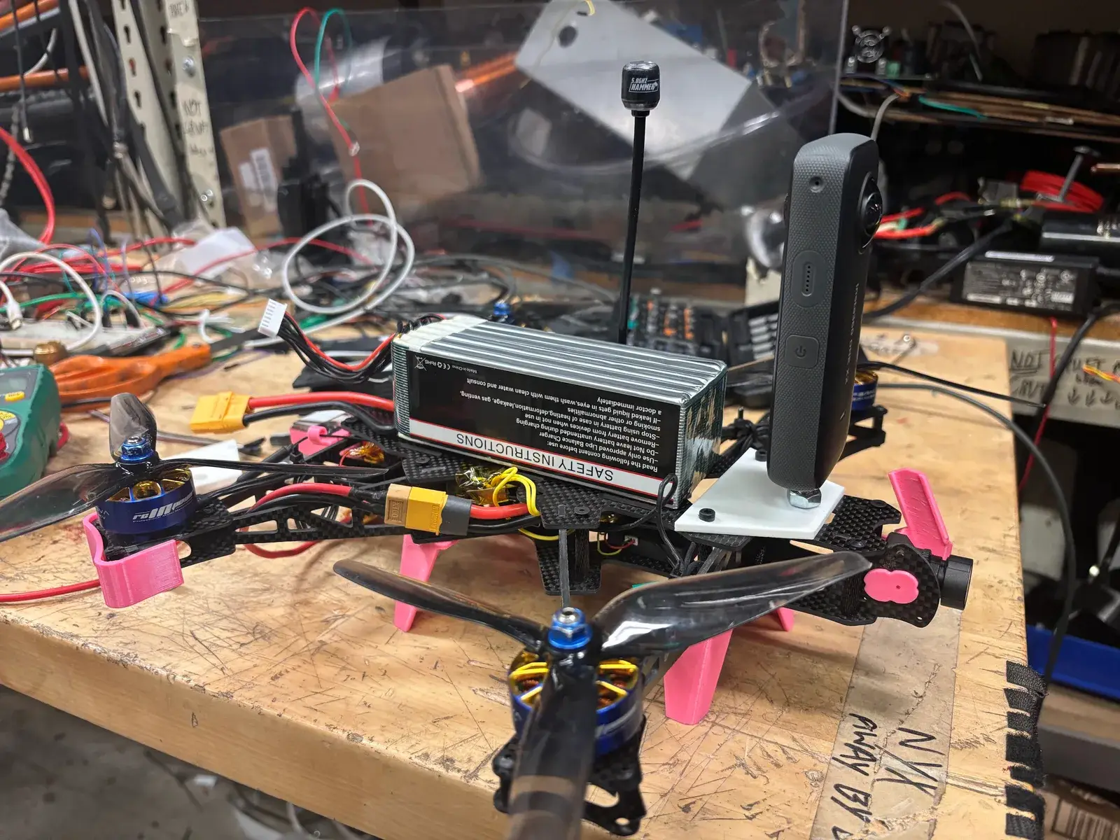 The 360° build on the bench with the Insta360 mounted on top and the battery strapped behind