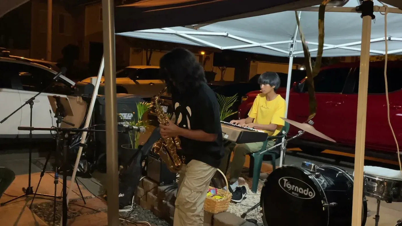 AJ on keys with a saxophonist at an outdoor gig