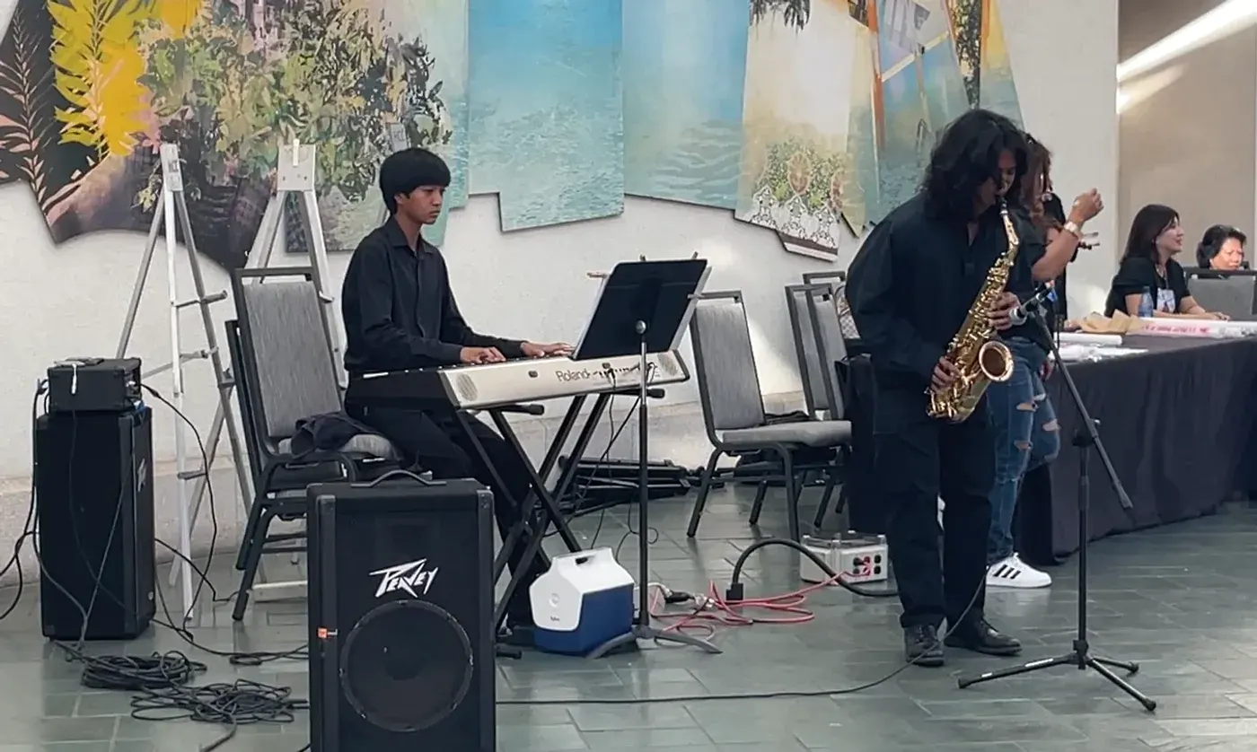 AJ on keyboard with a saxophonist at an event