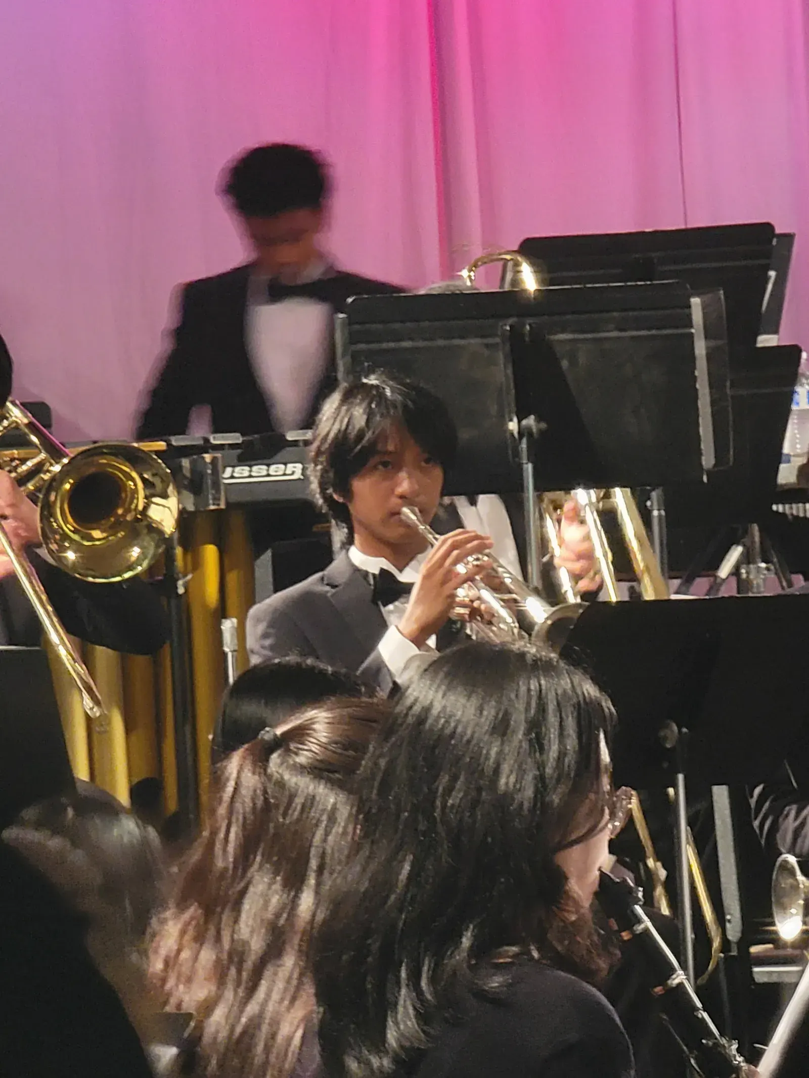 AJ playing trumpet under stage lights