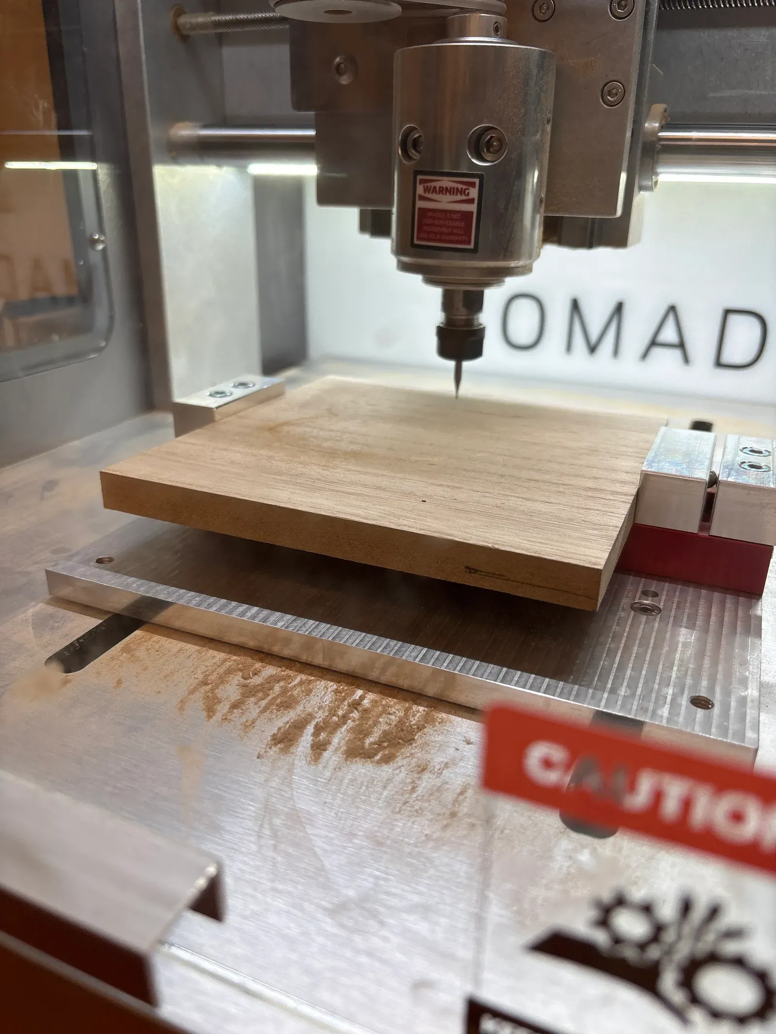 The desktop CNC cutting a wooden plate