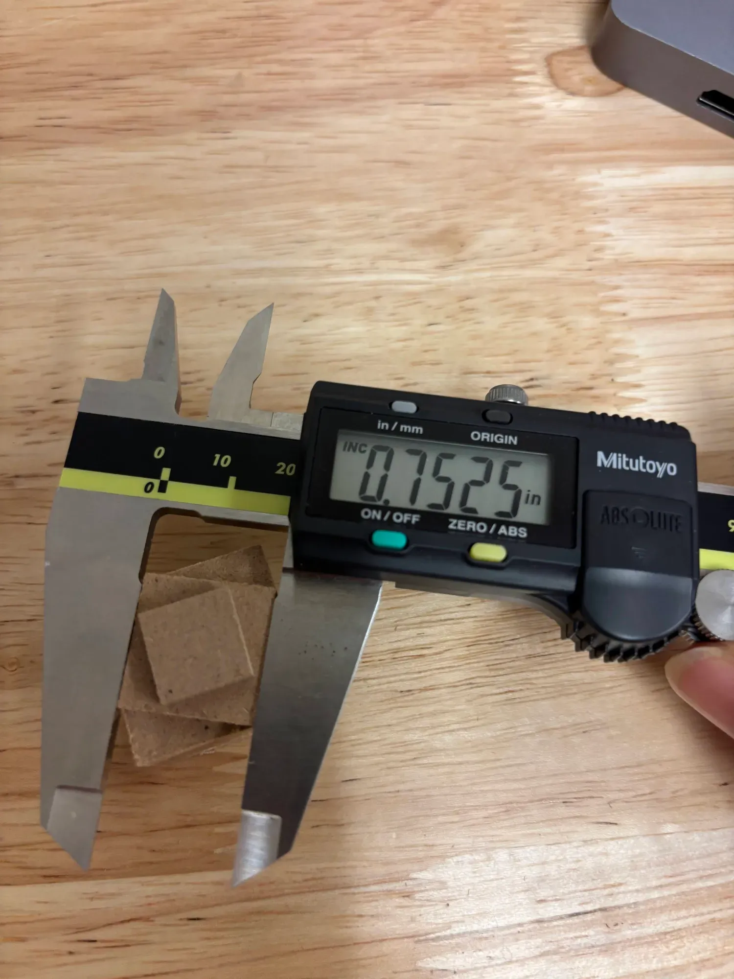 Measuring a machined test feature with digital calipers