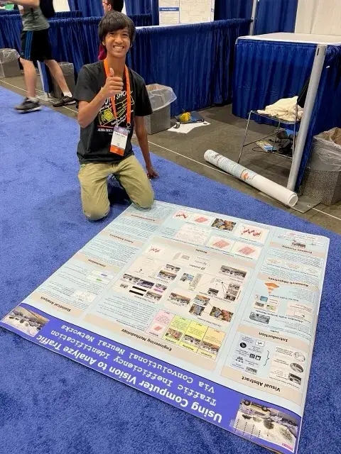 AJ with the project poster laid out on the floor at ISEF